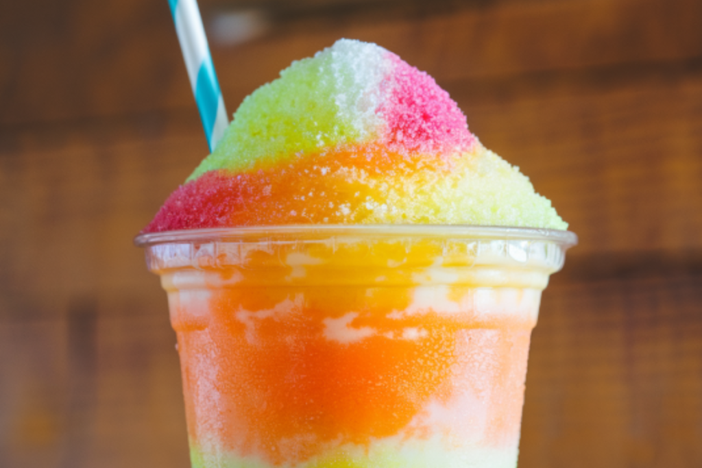 Refreshing slushie with vibrant colors, topped with a straw, perfect for a hot summer day.